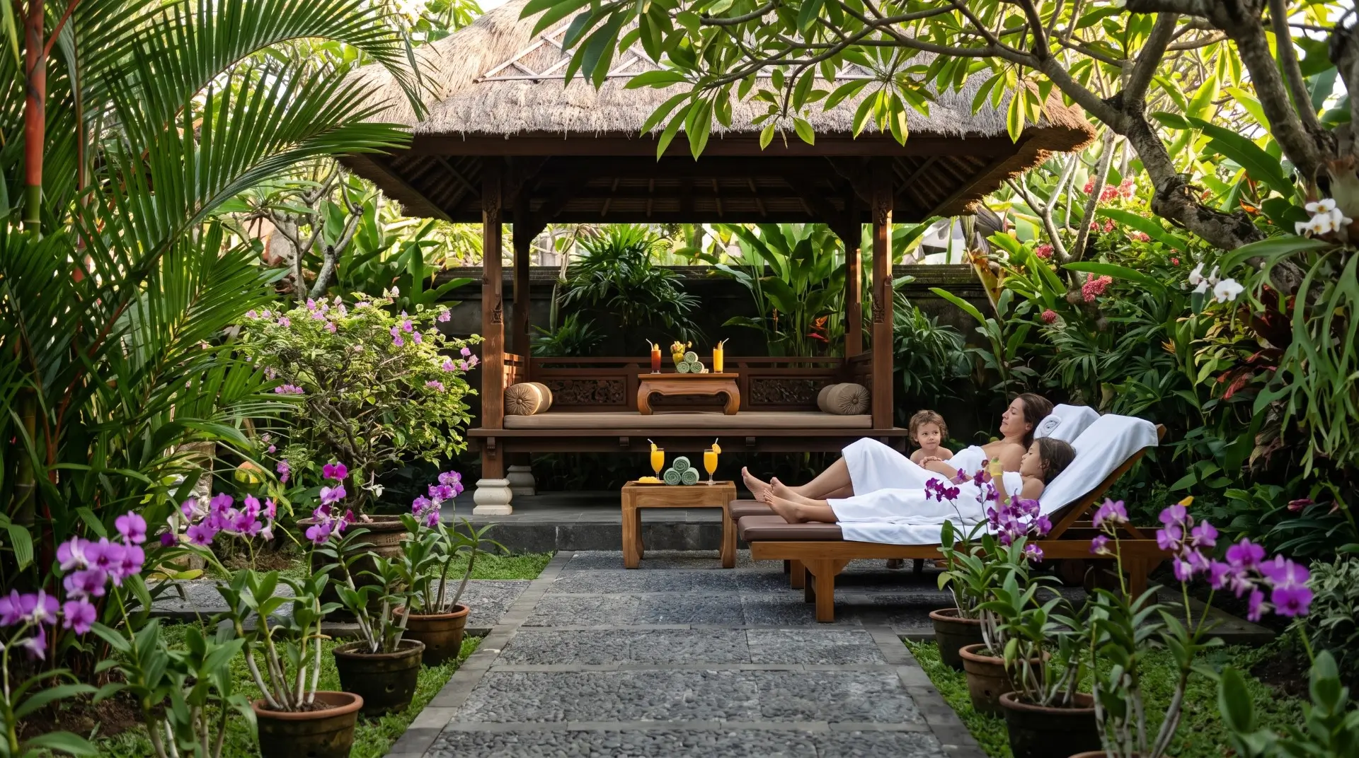 family massage packages parents and children receiving synchronized massage in tropical garden